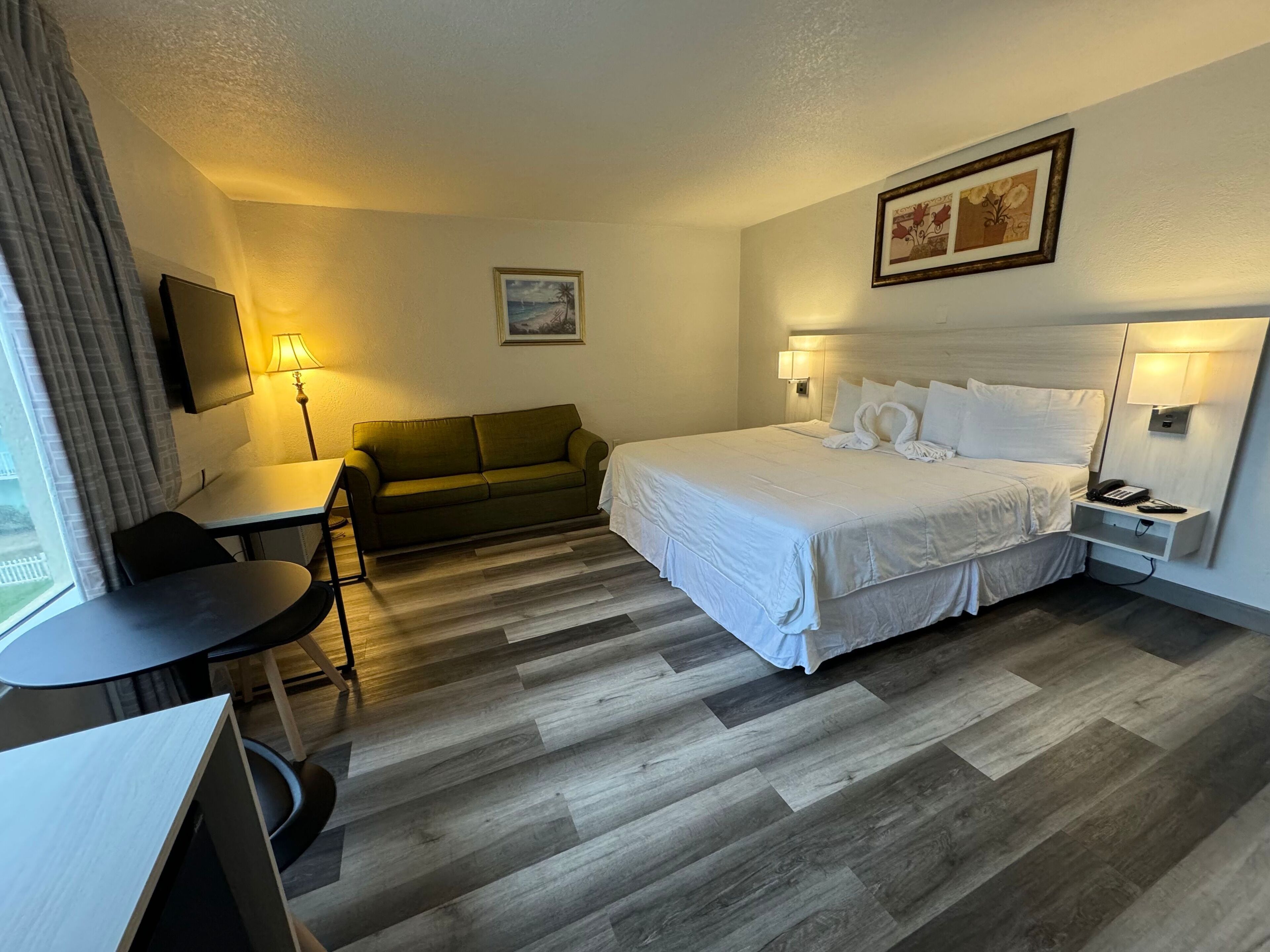Una habitación de hotel con cama, sofá, escritorio y silla.