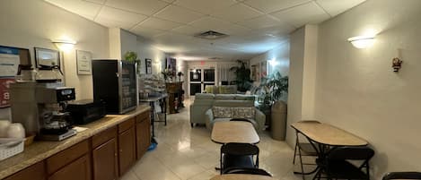 A cafe with a coffee machine, seating area, and a television.