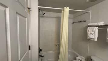 A bathroom with a bathtub, a shower curtain, and a towel rack with towels.