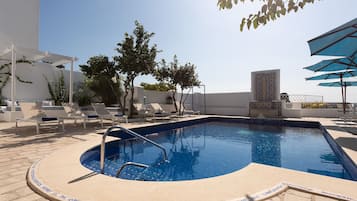 Een buitenzwembad en ligstoelen