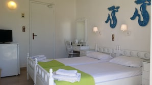 A hotel room with a bed, two bedside tables, a desk with a chair, a television, and a large mirror. - Hotel Rachel (Aegina)
