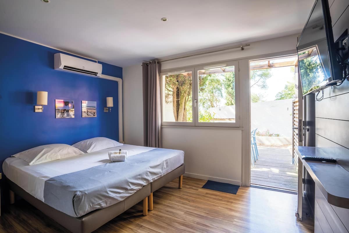 Un dormitorio con cama, ventana y equipo de aire acondicionado.