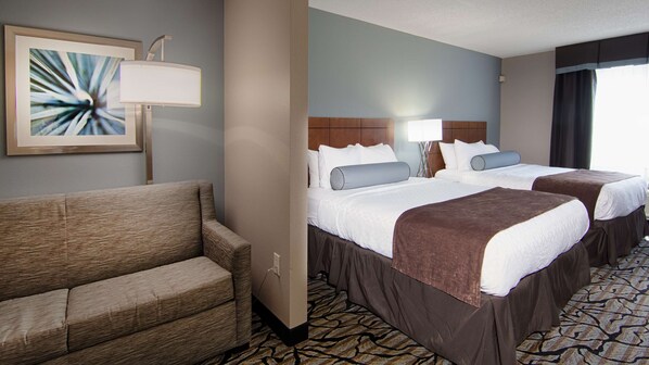 A hotel room with two beds, a sofa, a lamp, and a framed picture on the wall. - Best Western Plus Blaine at the National Sports Center (Blaine)
