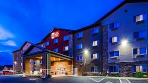 Un hotel de varios pisos con un llamativo letrero Best Western PLUS, un acceso cubierto y un estacionamiento con acceso para discapacitados.