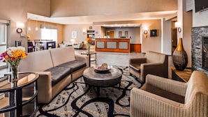 Un vestíbulo moderno con sofá, sillones, una mesa de centro y una recepción.