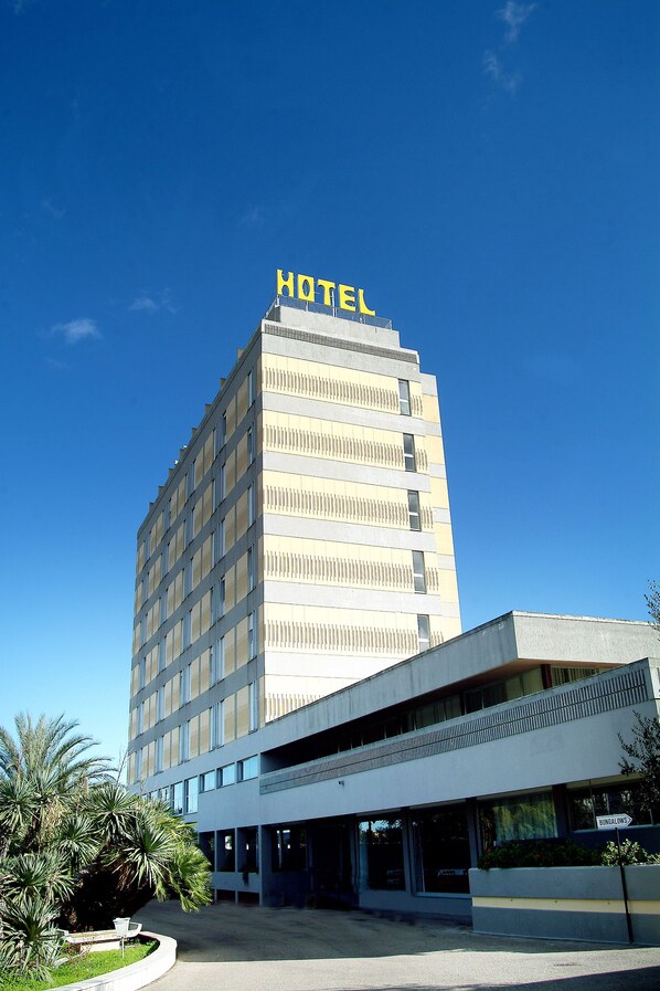 A hotel with a modern design, featuring a prominent 'HOTEL' sign on the top.