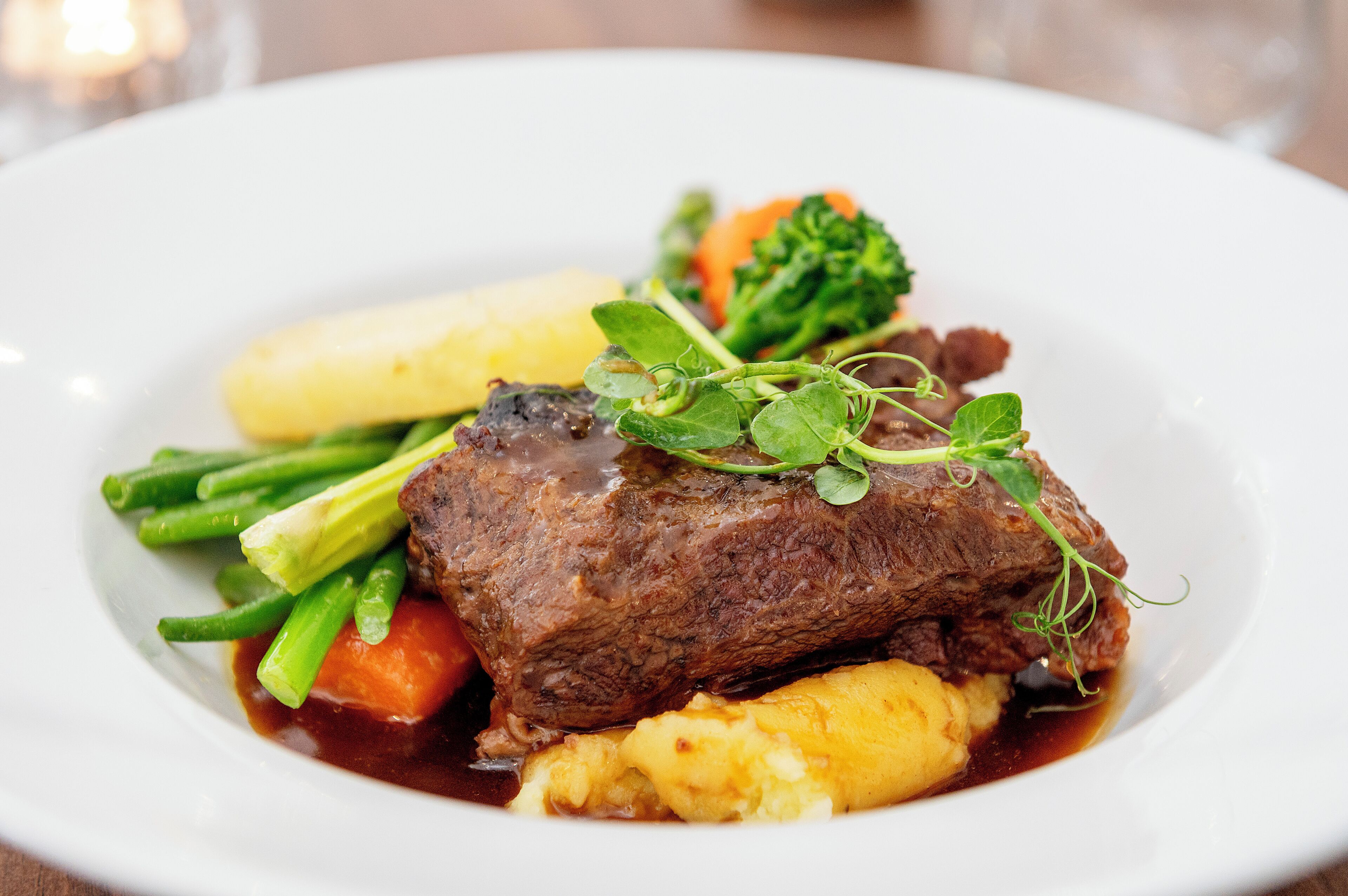 A plate of food with meat, vegetables, and a sauce.