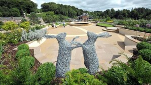 A landscaped garden with a central circular area, surrounded by various plants and trees. - New Lanark Mill Hotel (Lanark)