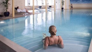 An indoor swimming pool with lounge chairs and potted plants. - New Lanark Mill Hotel (Lanark)