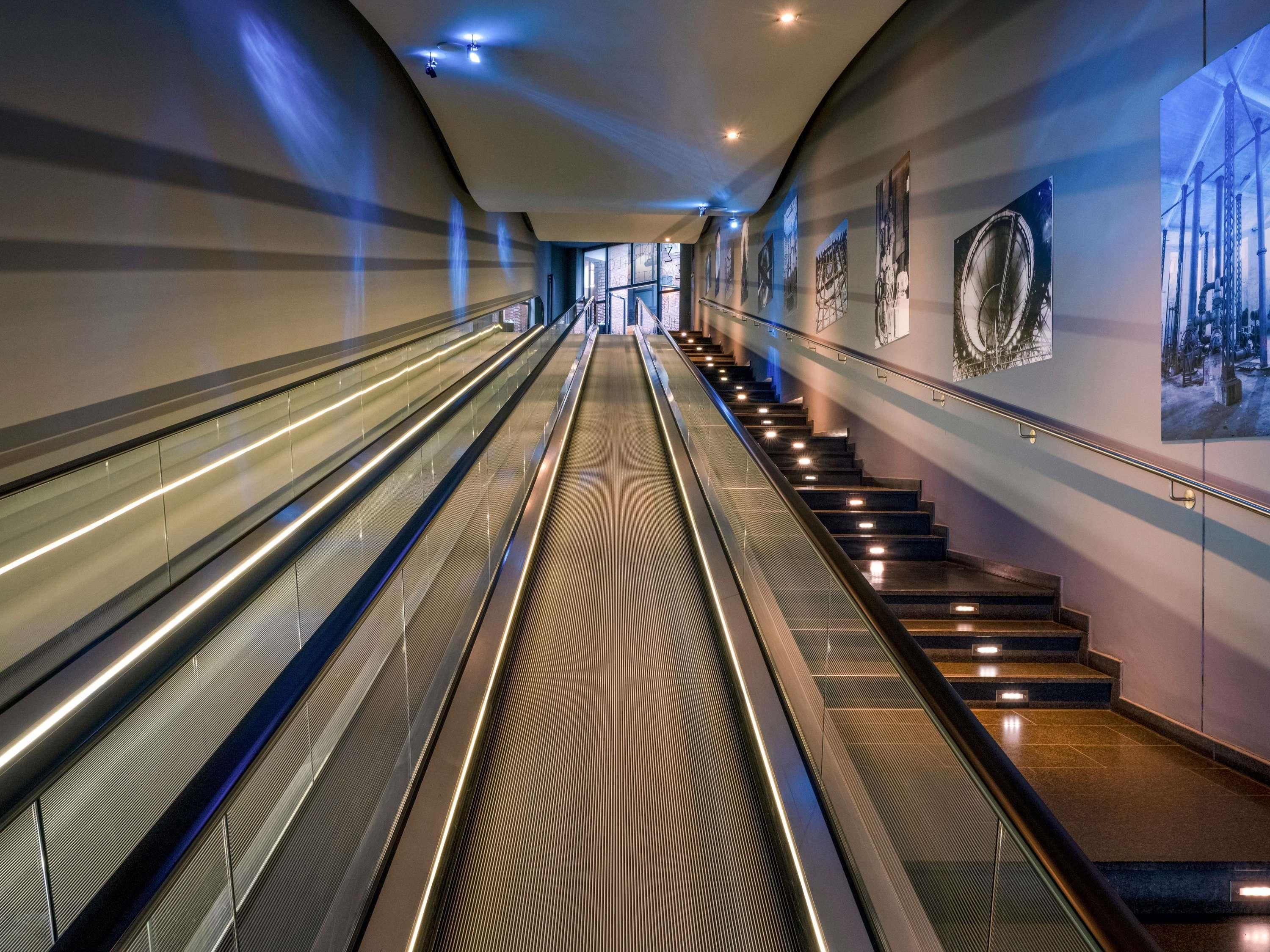 Eine Rolltreppe führt zu einer Treppe mit einem gemusterten Boden.