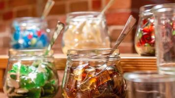 A row of glass jars with various contents on a wooden shelf.