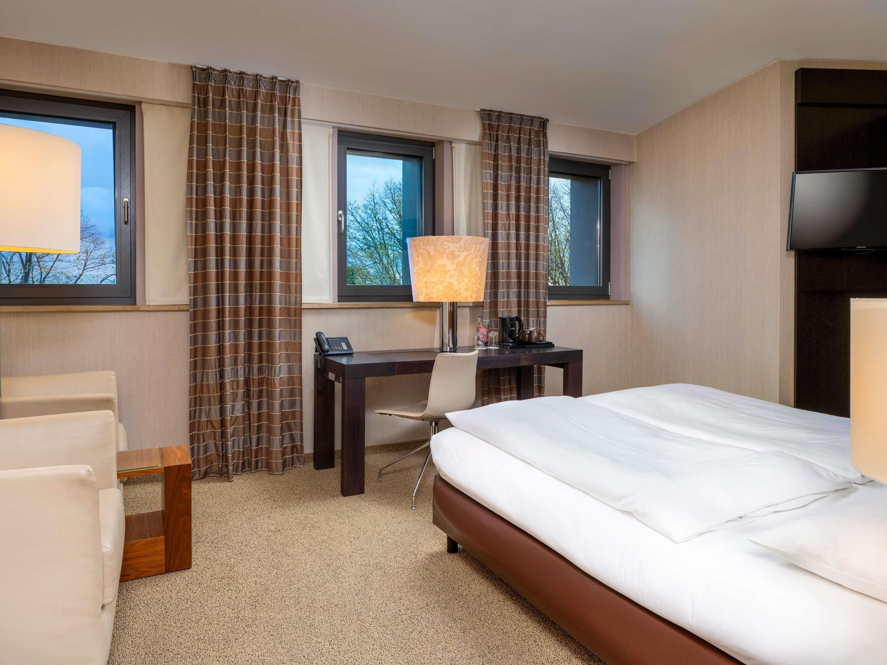Une chambre d’hôtel équipée d’un lit, d’un bureau, d’une chaise et d’un téléviseur.