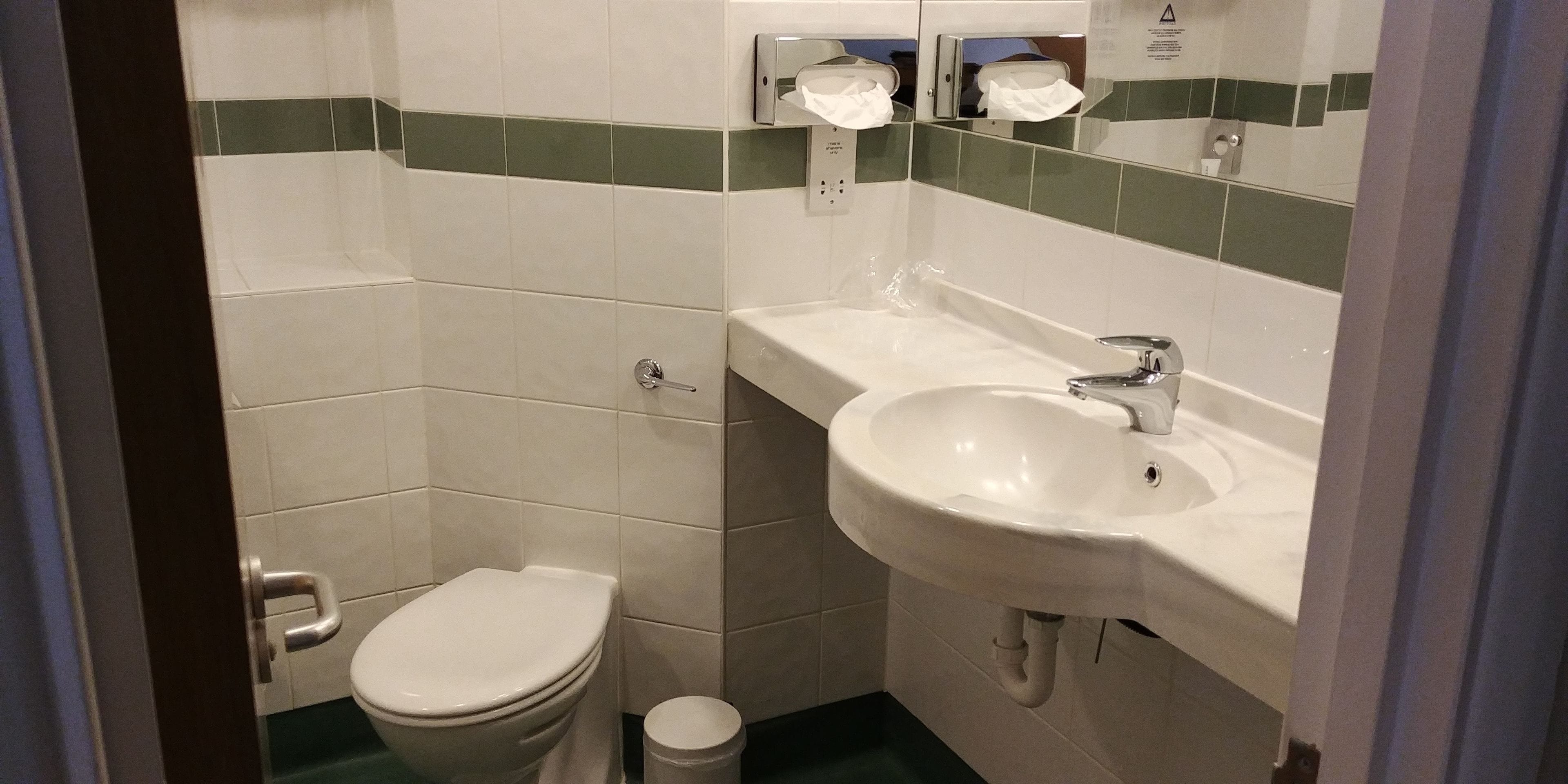 Un baño pequeño con inodoro, lavabo y espejo.