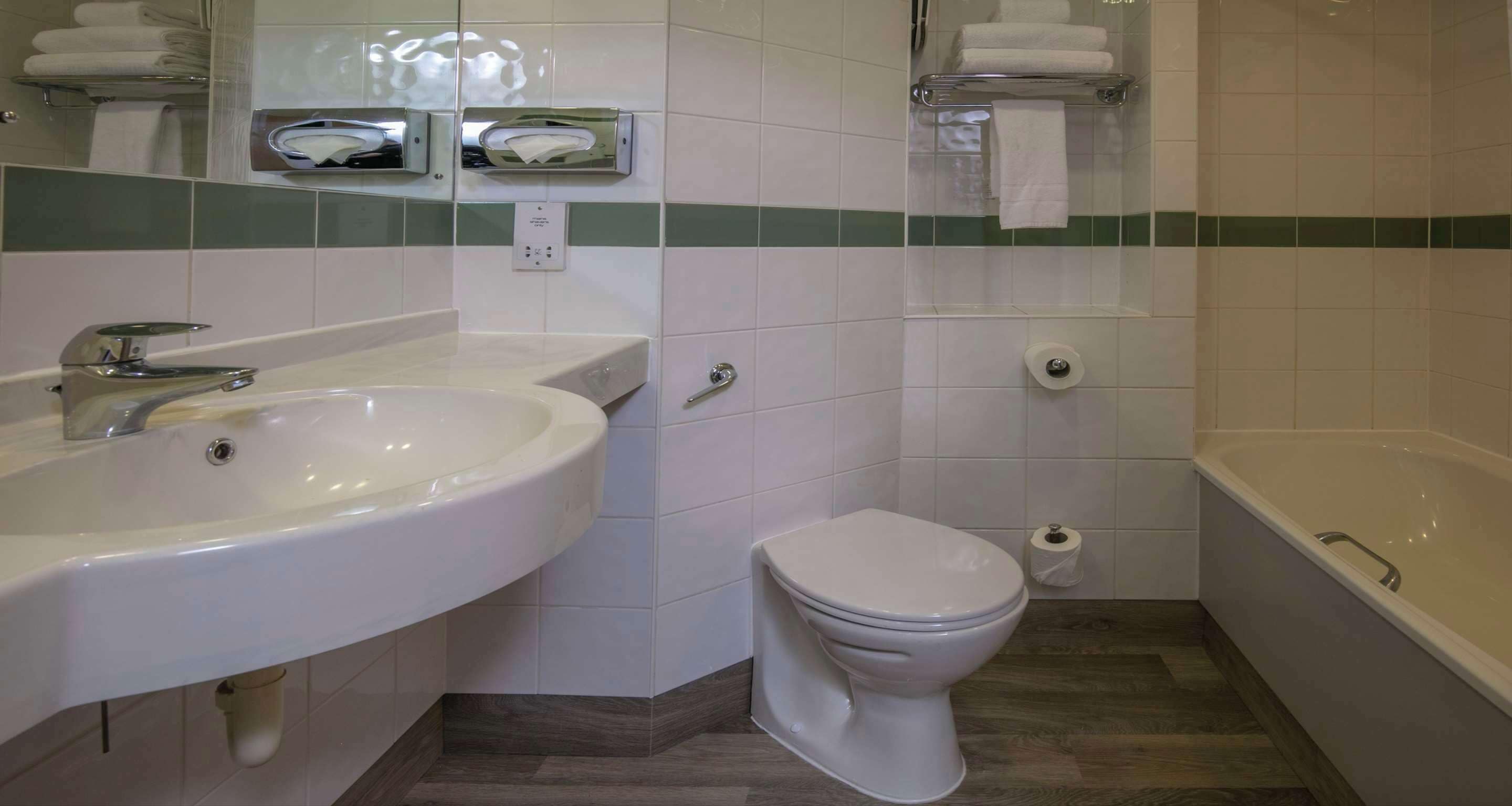 A bathroom with a sink, toilet, and bathtub.