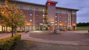 A multi-story hotel with a prominent 'Ramada' sign, a covered entrance, and a landscaped driveway. - Ramada Plaza by WyndhamWrexham (Wrexham)