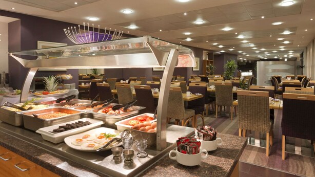 A buffet area with various food options and seating arrangements. - Ramada Plaza by WyndhamWrexham (Wrexham)