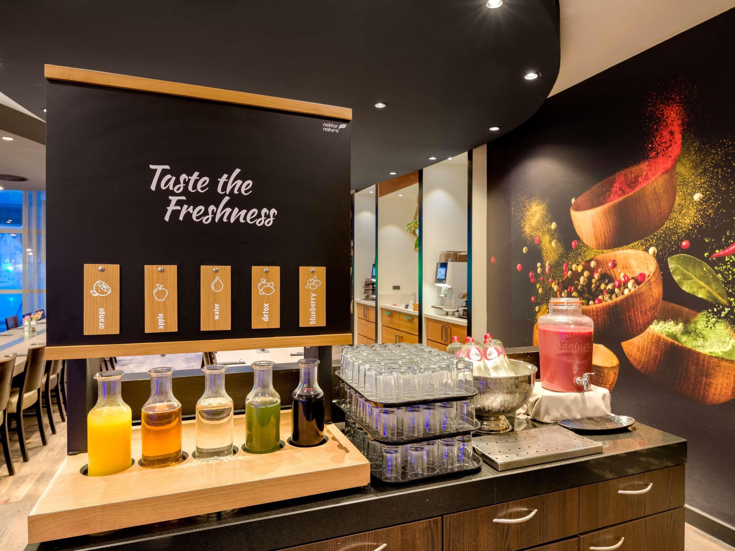 A juice bar with a sign reading 'Taste the Freshness,' featuring orange, apple, water, detox, and blueberry flavors.