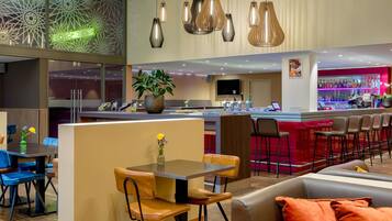 Un bar moderno con barra, asientos e iluminación decorativa.