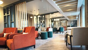 A modern lounge area with seating arrangements, wooden paneling, and pendant lighting. - Smiths at Gretna Green (Gretna)
