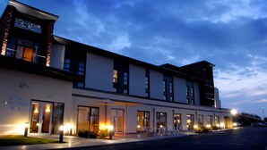 A modern hotel with a glass facade, a sign for banquet and conference suites, and outdoor seating. - Smiths at Gretna Green (Gretna)