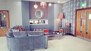 A modern lobby with a sofa set, a lamp, and a patterned wall. - Smiths at Gretna Green (Gretna)