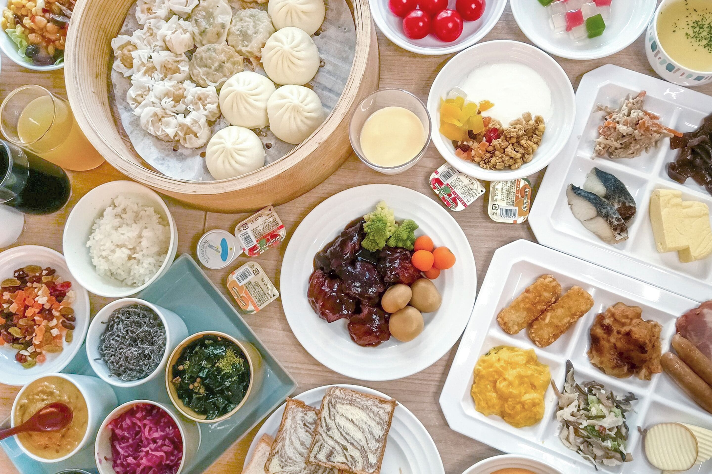 A variety of dishes including dumplings, rice, and vegetables on a wooden table.