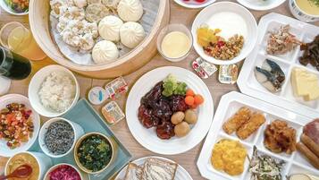 A variety of dishes including dumplings, rice, and vegetables on a wooden table.