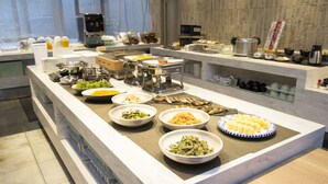 A buffet with various dishes and a coffee machine.