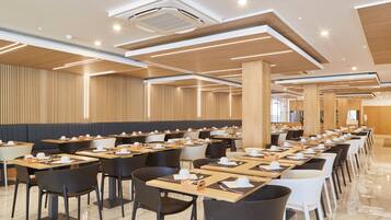 A spacious dining area with multiple tables and chairs, arranged in rows.