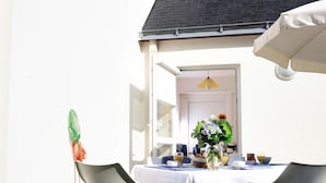 Un bâtiment blanc avec un toit noir et une porte donnant sur l’intérieur.