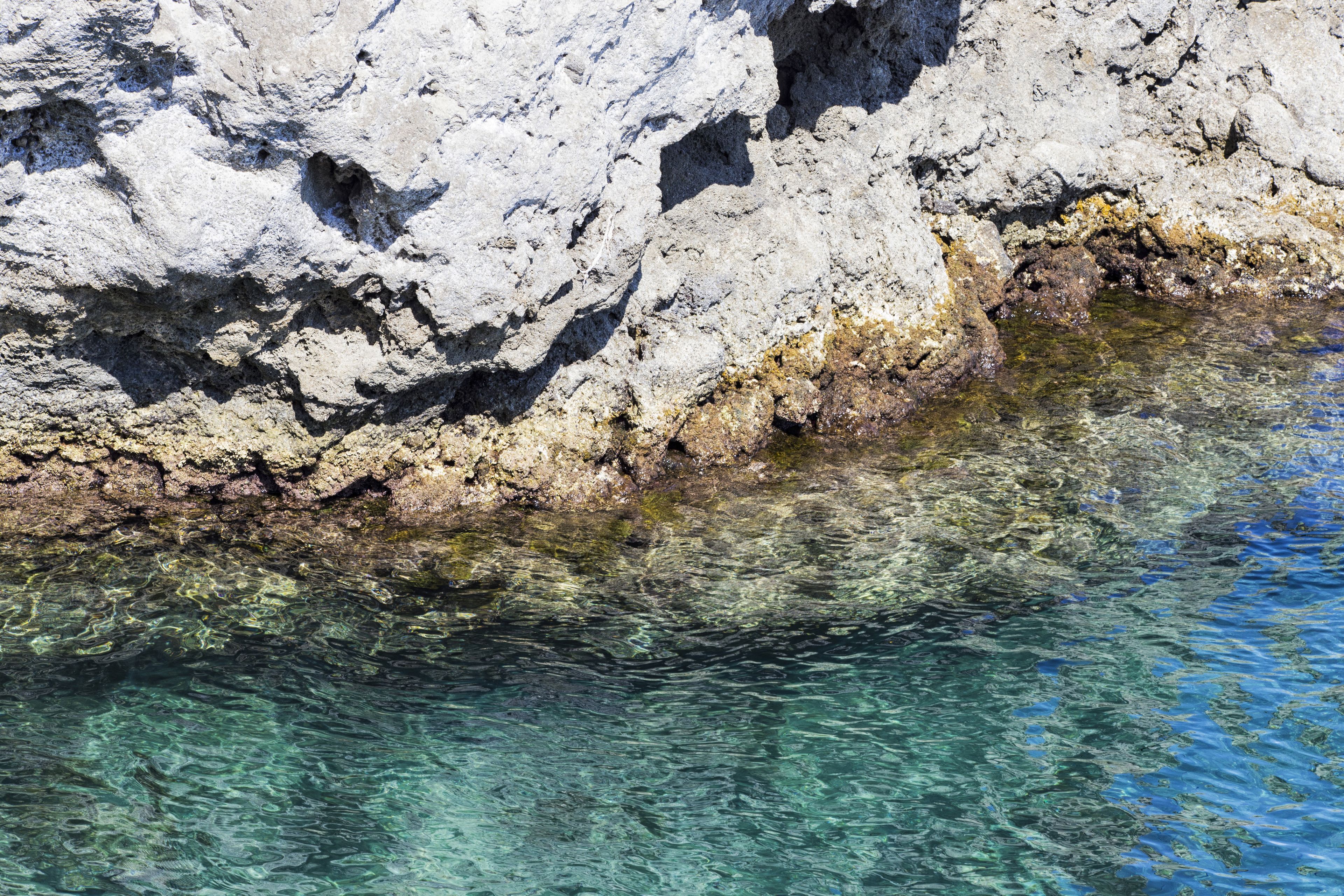 A rocky shoreline with clear water.
