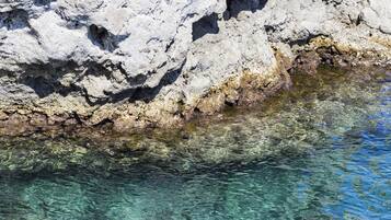 A rocky shoreline with clear water.