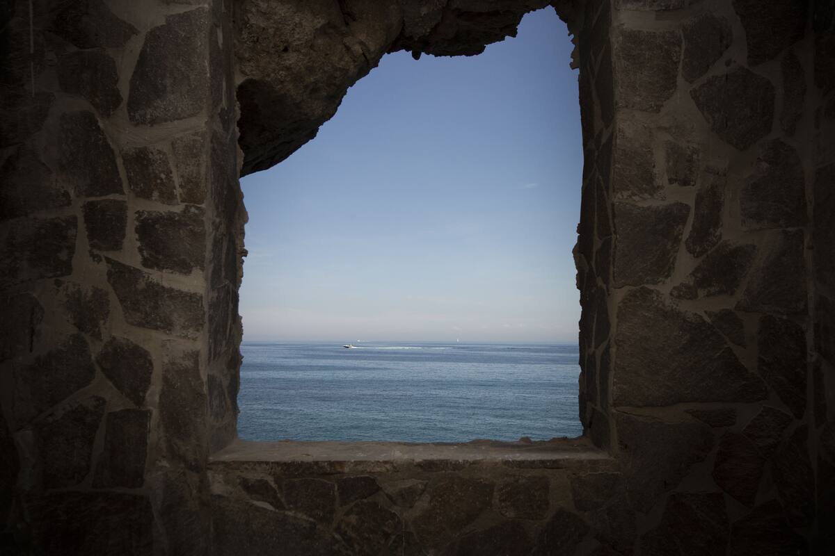 A stone window with a view of the ocean.