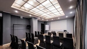 A conference room with a large screen, a whiteboard, and a projector. - Rija VEF Hotel (Riga)