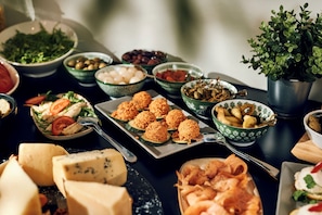 A table with various food items including cheese, olives, and salads.