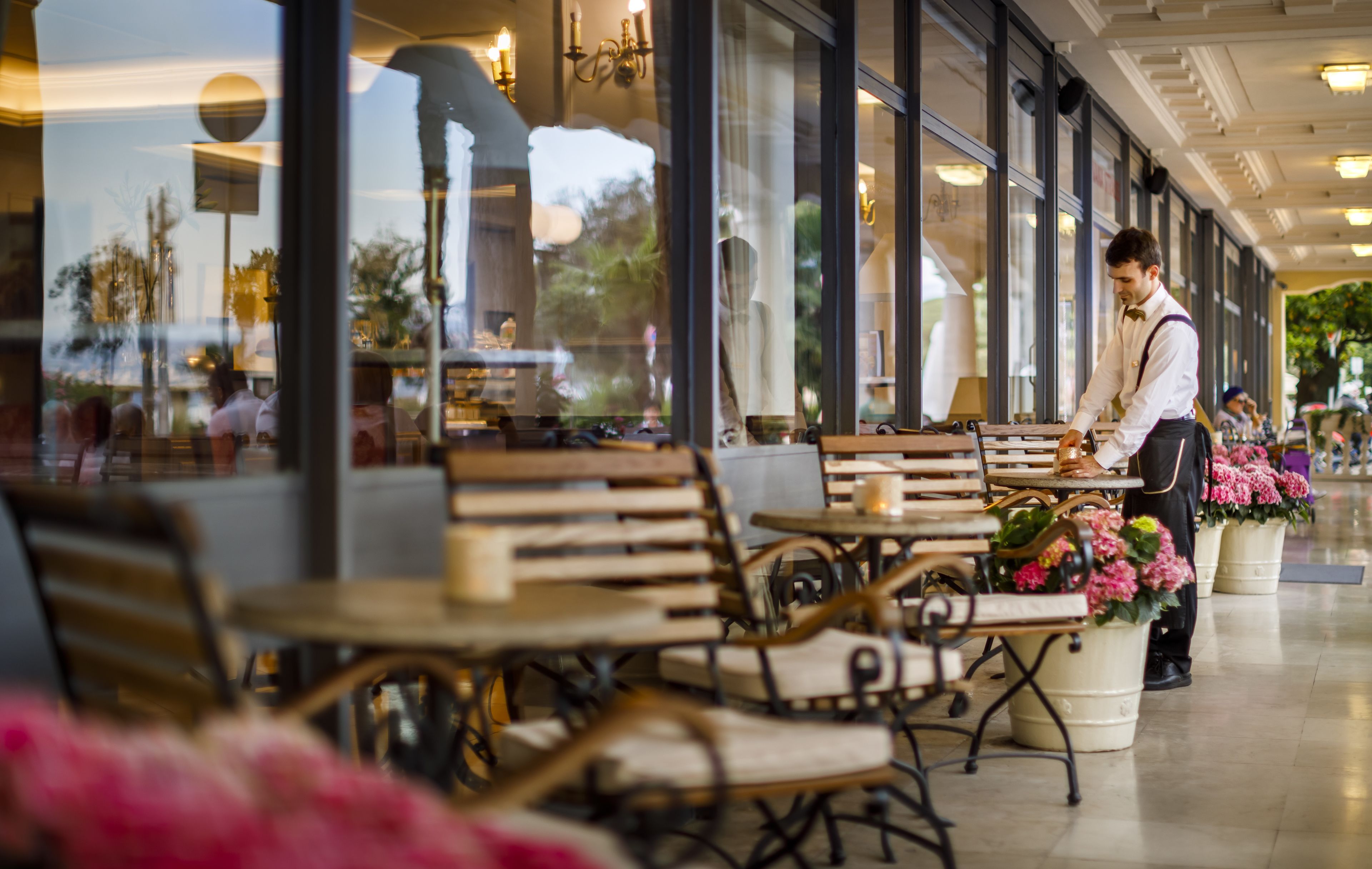 A cafe with wooden furniture and potted plants.