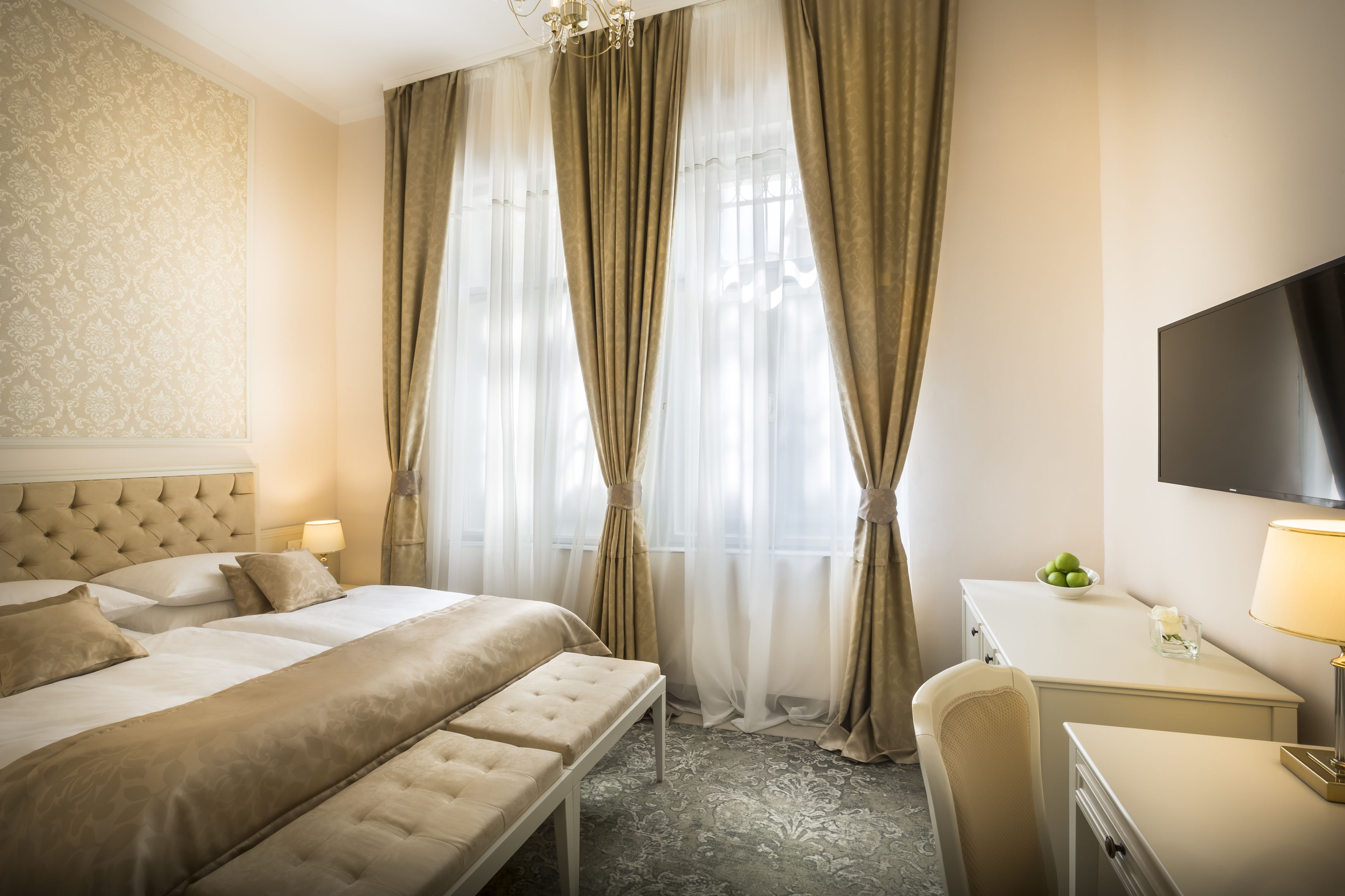 Ein Hotelzimmer mit einem großen Bett, einem Schreibtisch und einem Fernseher.