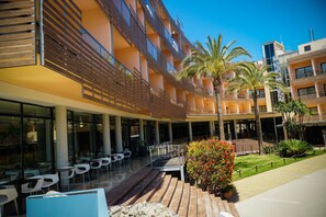 Enjoy the hotel's spacious outdoor area with seating, plants, and balconies.
