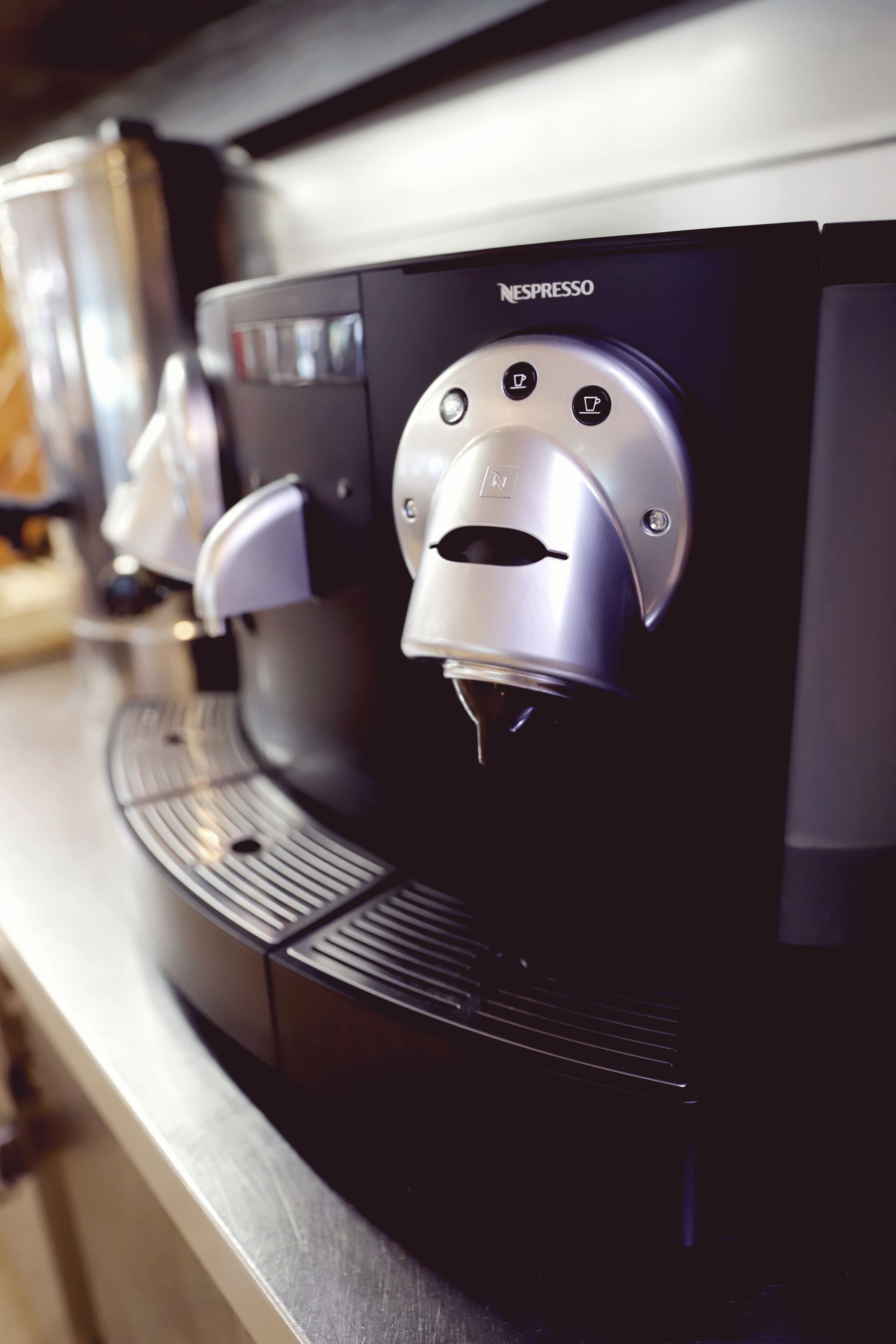 En Nespresso-kaffemaskin med en kontrollpanel och en droppuppsamlare.