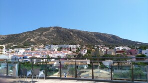 Un pueblo costero con una colina destacada al fondo, que presenta una mezcla de edificios residenciales y un faro.