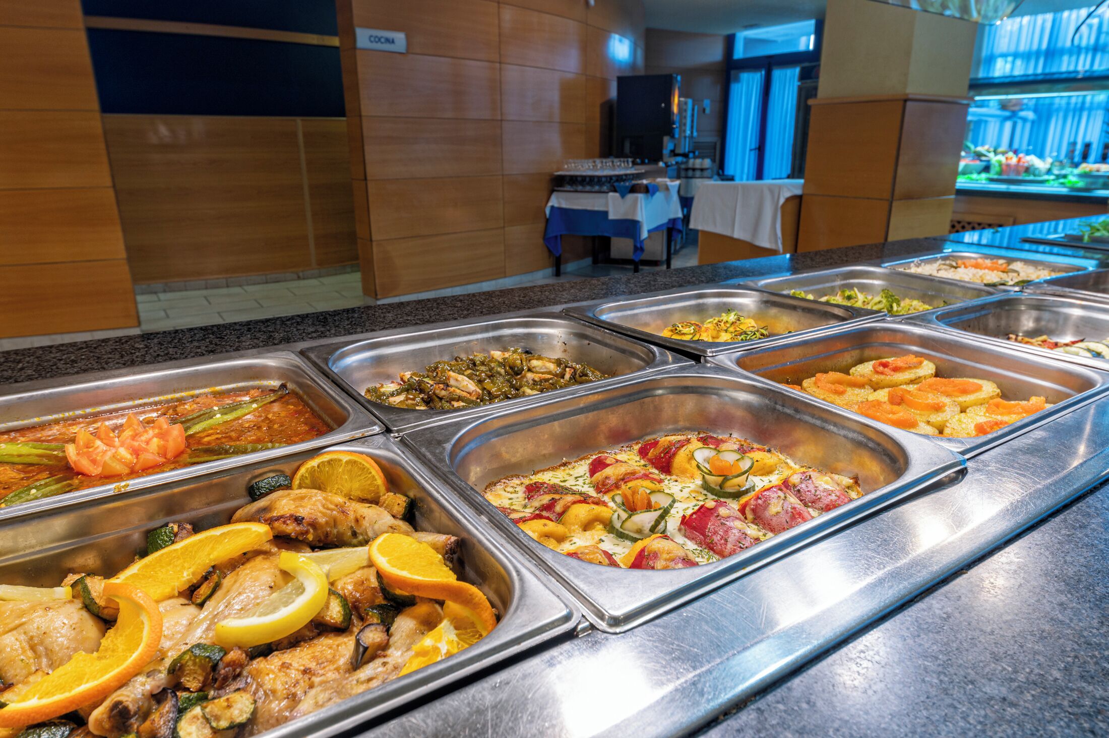 Buffet com diversos pratos, incluindo frutos do mar, legumes e carnes.