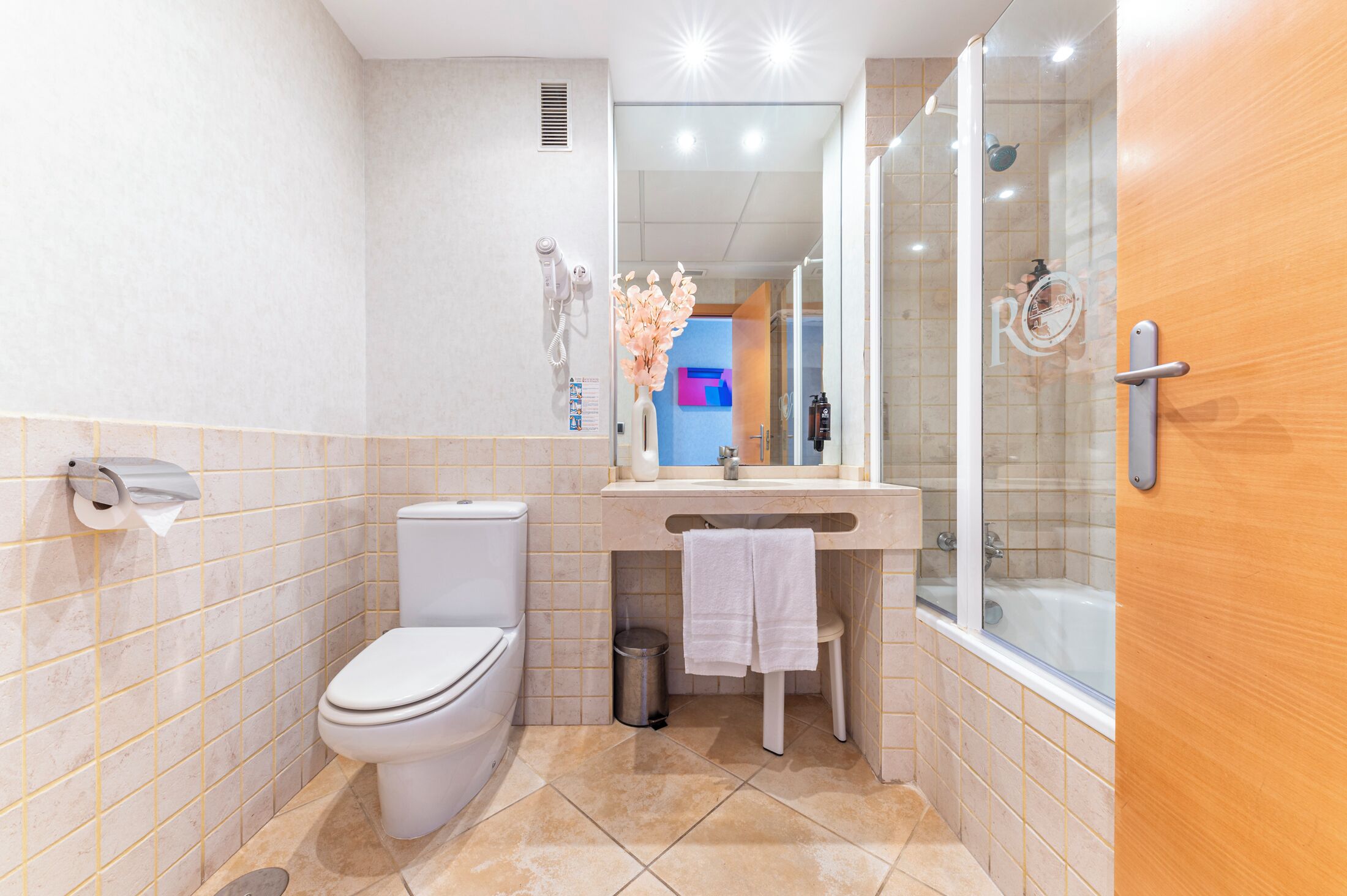 Un baño moderno con inodoro, lavamanos y ducha.