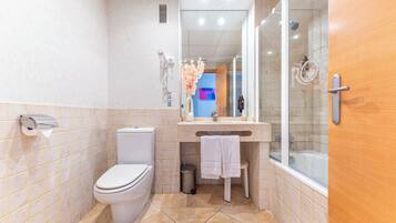 Un baño moderno con inodoro, lavamanos y ducha.