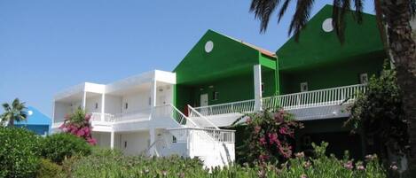 A two-story building with a green facade and white balconies.