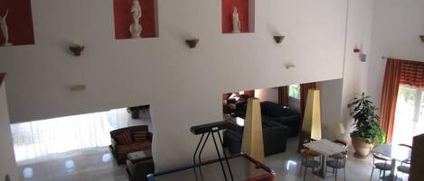 Amplia sala de estar con mesa de billar, sofás y una mesa de comedor.
