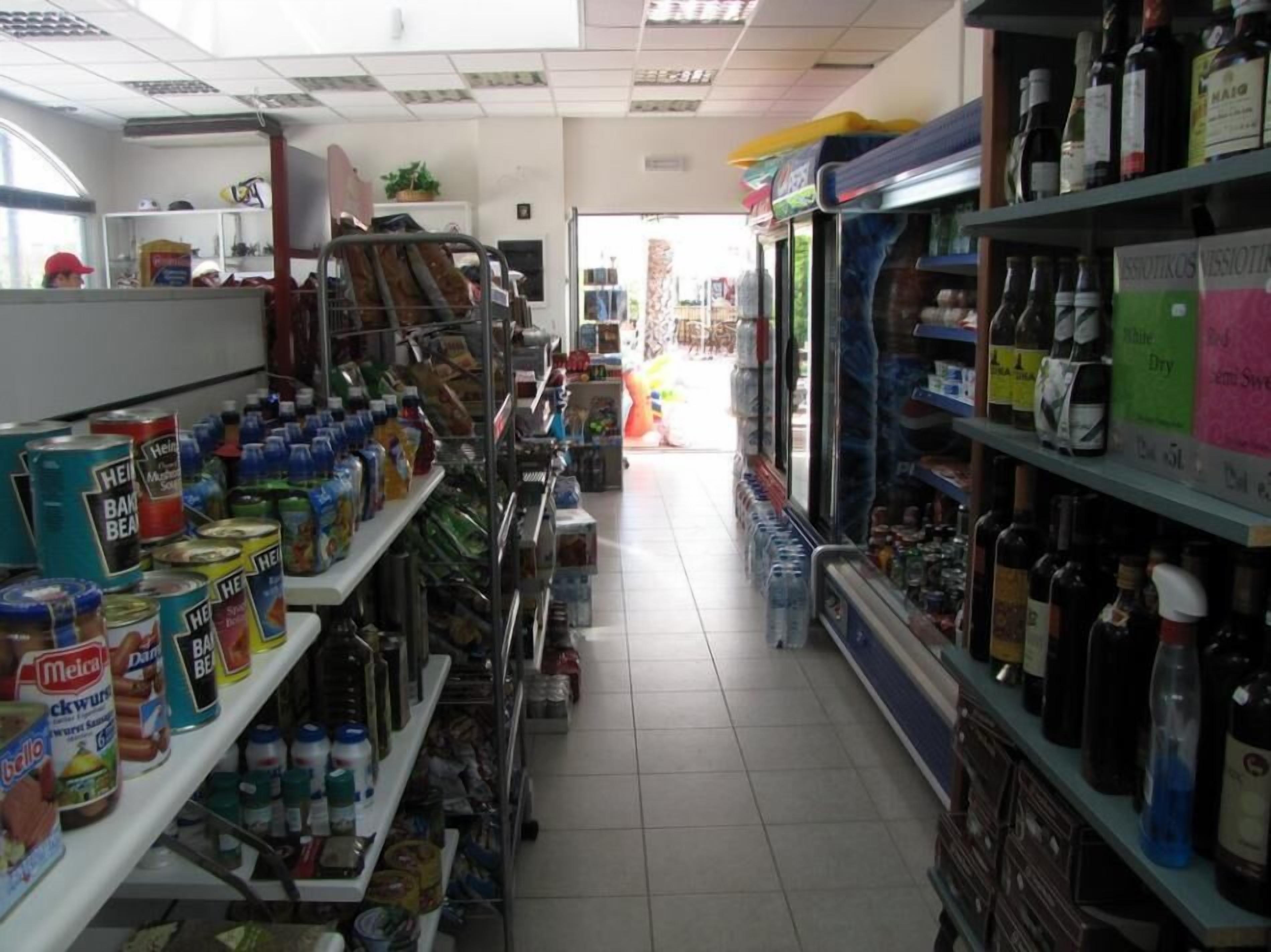 Un rayon de supermarché avec des étagères remplies de conserves, de bouteilles et de bocaux.