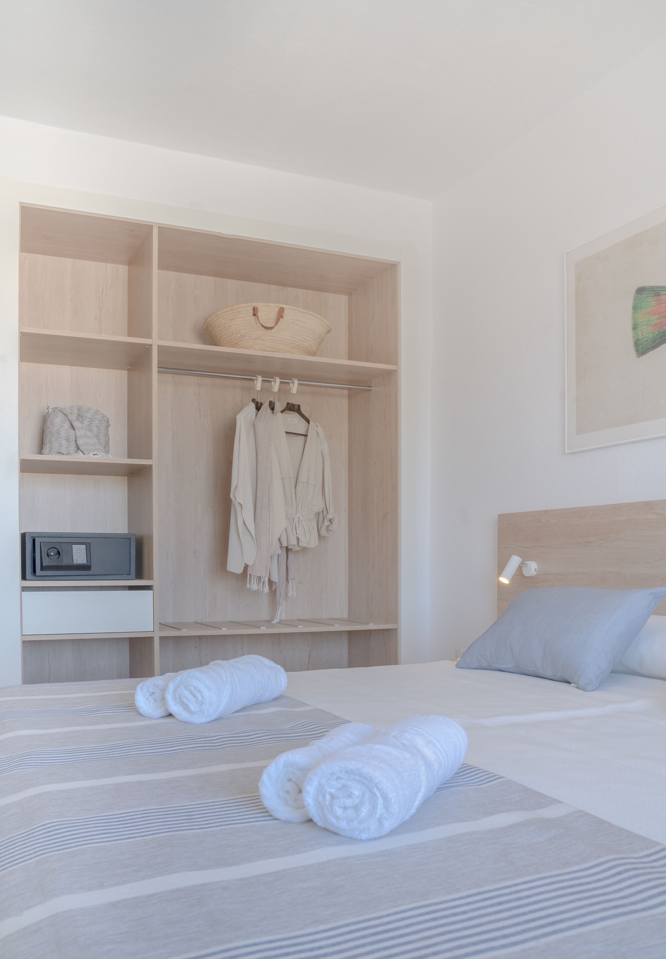 A neatly organized bedroom with a bed, a wardrobe, and a bedside table.
