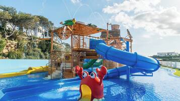 Un parque acuático con un tobogán azul, una estructura de juego de madera y una gran decoración de cangrejo en la piscina.