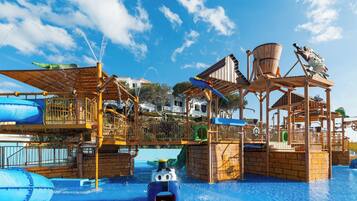 A water park with various play structures, slides, and a pool area.