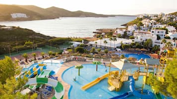 Una piscina al aire libre, sombrillas, sillones reclinables de piscina